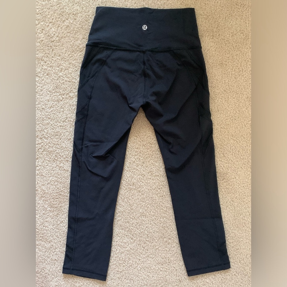 Lululemon high rise black capri leggings with mesh diagonal lines on the front.